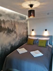 Schlafzimmer mit einem Bett mit Wandgemälde in der Unterkunft Apartament widokowy ul Bukowa Wisła in Wisła