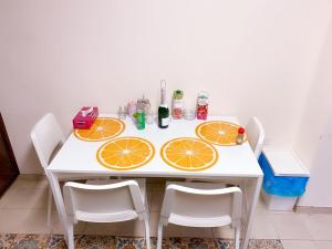 une table blanche avec des tranches orange dessus dans l'établissement City Comfort Rooms, à Larnaka