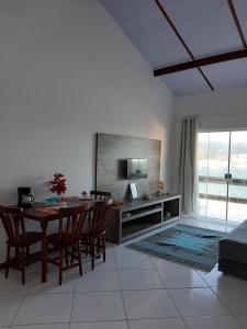 a living room with a table and chairs and a television at Bela Vista Flats in Arraial do Cabo