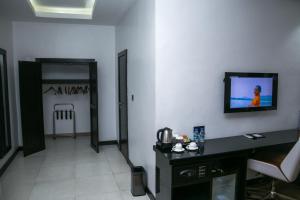 um quarto com uma secretária e uma televisão na parede em GreenPoint Hotel em Lagos