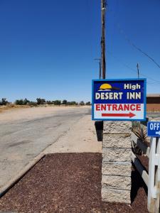 una señal para una entrada de una posada en el desierto a un lado de una carretera en High Desert Inn, en Hesperia