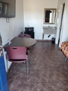 Cette chambre dispose d'une table, de chaises et d'un lavabo. dans l'établissement High Desert Inn, à Hesperia