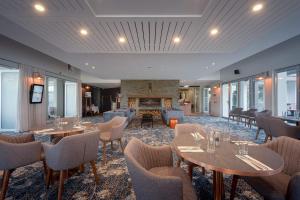 a restaurant with tables and chairs and a fireplace at Peppers Clearwater Resort in Christchurch