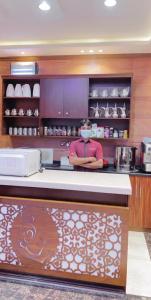 a person in a kitchen with a face mask at Aseel Furnished Apartments in Jeddah
