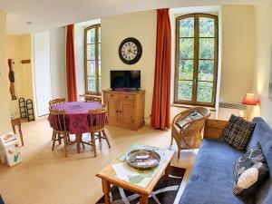 a living room with a blue couch and a table at Appartement 202 Résidence du Grand Hotel Aulus-les-Bains in Aulus-les-Bains