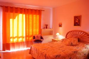 ロス・クリスティアーノスにあるJardín Canario Primera línea de Playaのベッドルーム1室(ベッド1台、窓、椅子付)