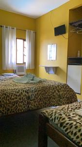 a room with two beds in a leopard print at Pousada Pratagy in Saquarema