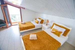 a white room with two beds and a window at House near CR7 Museum in Funchal