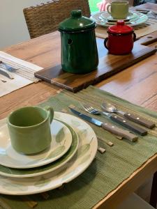 una mesa con una taza verde y platos en ella en Resort Villas do Pratagy, en Maceió