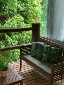 a bench sitting on a porch with a window at Resort Villas do Pratagy in Maceió