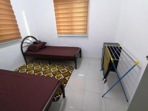 Camera piccola con letto e sedia di Amani Apartment Homestay a Malacca