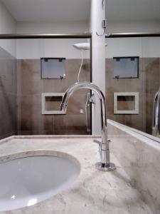 uma casa de banho com um lavatório e um espelho em Sleep Hotel Assis em Assis Chateaubriand