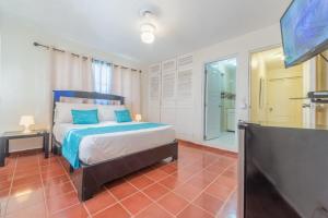 a bedroom with a bed and a flat screen tv at Sosua Sweet Vacations in Sosúa