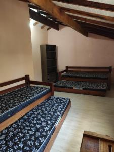a room with three beds in a room at Sarau's Beach House Boracéia in Boracéia