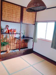 a room with a room with a table and windows at Guest House Kominka Nagomi in Izumi-Sano