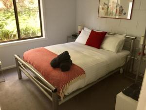 - une chambre avec un lit doté d'oreillers rouges et blancs dans l'établissement 970 Adventure Bay Road, à Adventure Bay