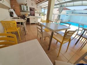 une salle à manger avec des tables et des chaises ainsi qu'une piscine dans l'établissement Hotel Magnólia, à São João da Boa Vista