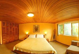a bedroom with a large bed with a wooden ceiling at La Casa del Molino Blanco B&B in Baños