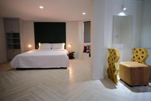 a bedroom with a white bed and a chair at Silom Apartment Close to BTS +WIFI+Netflix in Bangkok