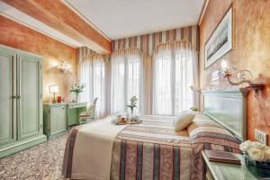 a bedroom with a bed and a desk in a room at Hotel Firenze in Venice