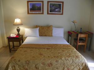 a bedroom with a bed with two night stands and two tables at Hotel Ipsan Nah in La Esperanza