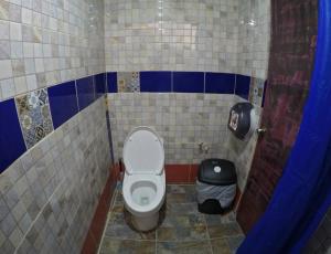 een badkamer met een toilet en een vuilnisbak bij Iguana Hostel Oaxaca in Oaxaca City