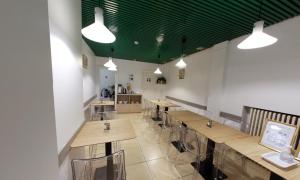 un restaurante con mesas de madera y techo verde en Sun Hotel, en Bruselas
