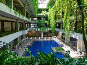 an indoor pool in a building with chairs and plants at HOTEL MOON BEACH MUSEUM RESORT in Onna +75 photos