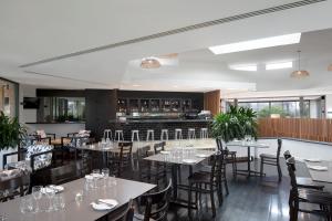 un restaurante con mesas y sillas y un bar en Mantra Sun City, en Gold Coast