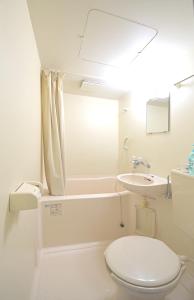 a white bathroom with a toilet and a sink at Yakushima Minsyuku Suginoko in Yakushima