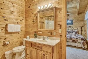 a bathroom with a sink and a toilet in a log cabin at Smoky Mountain Gem in Gatlinburg