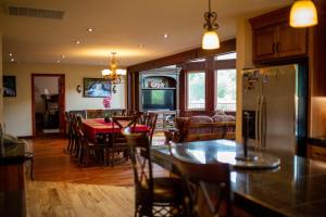 a kitchen and dining room with a table and a refrigerator at Riverfront Property with Waterfalls near Yosemite and Bass Lake in Oakhurst