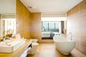 a bathroom with a white tub and a sink at Jimbaran Bay Beach Resort and Spa by Prabhu in Jimbaran