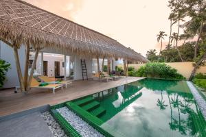 a swimming pool with a canopy over the top of it at Emerald Maldives Resort & Spa-Deluxe All Inclusive in Raa Atoll