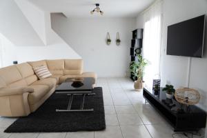 a living room with a couch and a tv at Pinet , le calme proche de la mer in Pinet