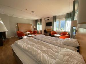 a bedroom with a large bed and orange chairs at Vandrarhemmet Hörneborg in Örnsköldsvik