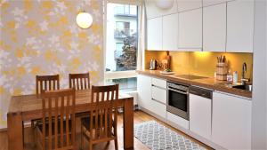 cocina con armarios blancos y mesa de madera en Fabulous Location Apartments, en Tallin