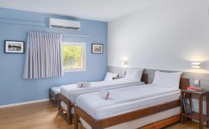 three beds in a room with a blue wall at Gvulot - Kibbutz experience in Gevulot +46 photos
