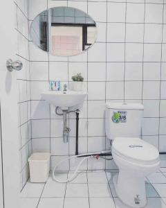 a bathroom with a toilet and a sink and a mirror at Gfeel Hostel in Bangkok
