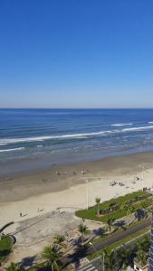 een uitzicht op een strand met mensen en de oceaan bij Casa 100mtrs do mar com piscina aquecida in Praia Grande