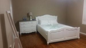 a bedroom with a white bed and a dresser at 35 By Sea in East London