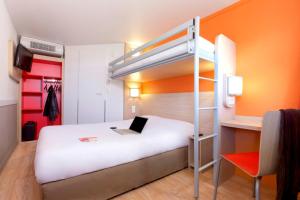 a bedroom with a bunk bed with a laptop on it at Premiere Classe Bordeaux Sud - Pessac Becquerel in Pessac