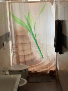 y baño con aseo y cortina de ducha. en Casa Casteldaccia 2, en Casteldaccia