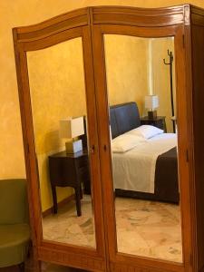 Habitación con dormitorio con cama y espejo. en Casa Casteldaccia 2, en Casteldaccia