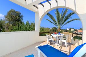 a patio with a table and chairs on a balcony at Follow The Sun Hotel Apartments in Polis Chrysochous