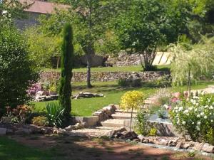 a garden with a stone wall and a stone path at Le CLOS BOURBON in Ferrières-sur-Sichon