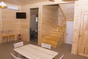 una sala da pranzo con un tavolo e una scala di Cottage in Sosnovom Boru a Kobleve