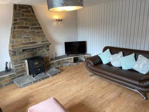 a living room with a couch and a fireplace at The Granary in Saundersfoot