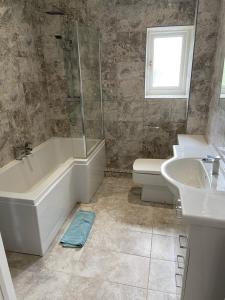 a bathroom with a tub and a sink and a toilet at The Granary in Saundersfoot