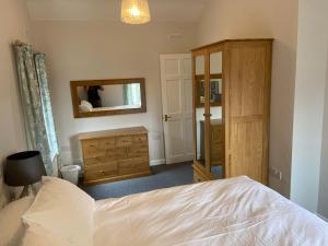 a bedroom with a bed and a dresser and a mirror at The Granary in Saundersfoot